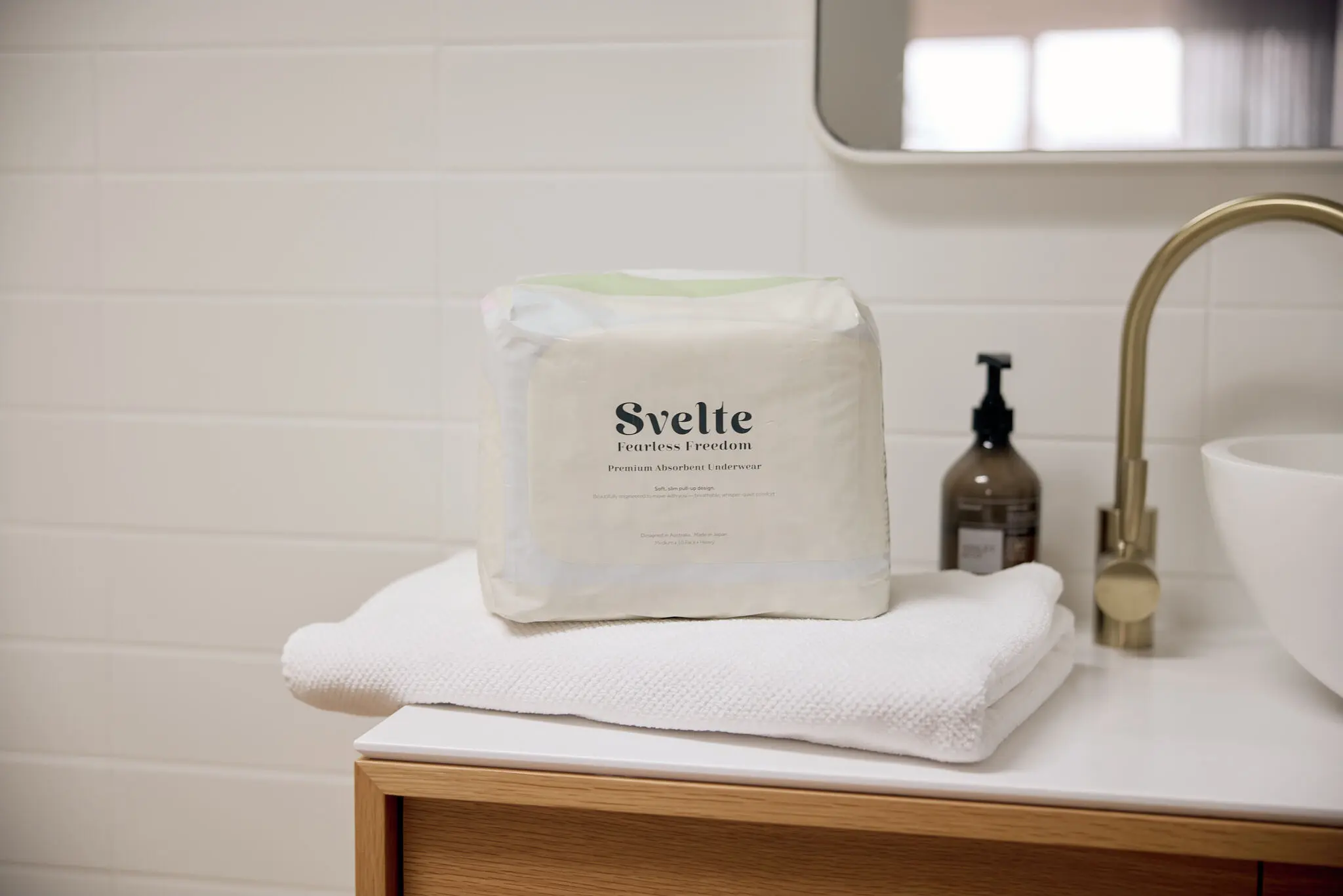 Svelte continence underwear pack displayed on folded towels in a softly styled bathroom.