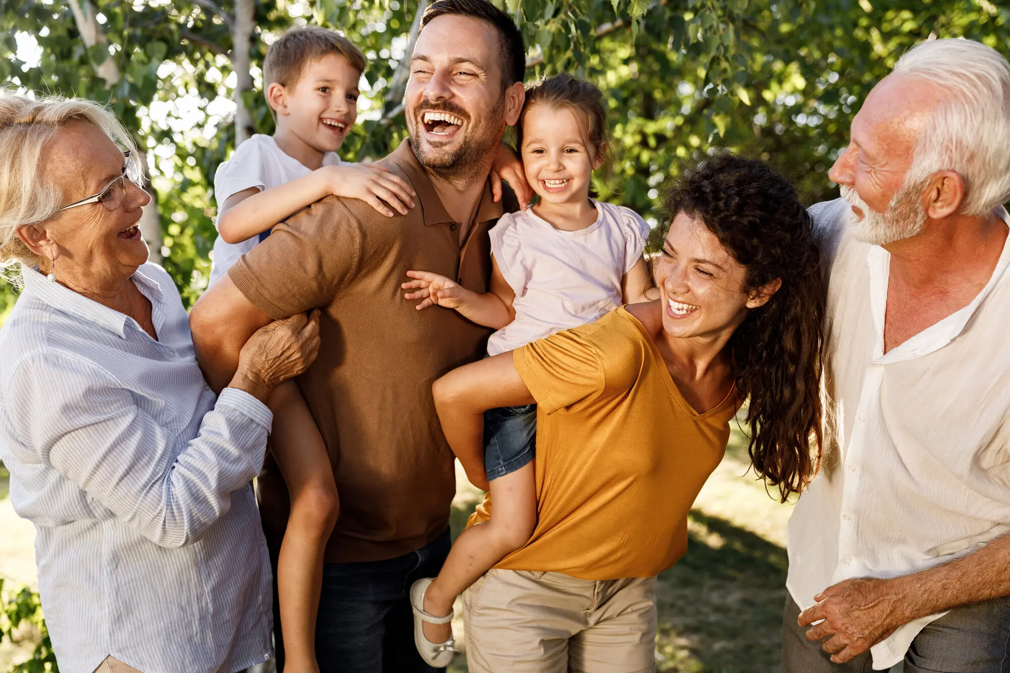 Multigenerational family laughing and spending time together outdoors.